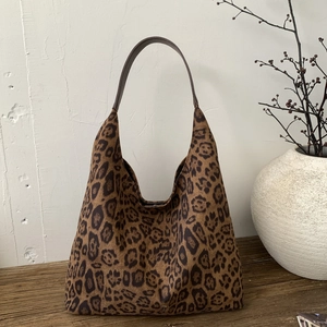 Close-up of leopard print tote bag with brown faux leather handles in a chic setting