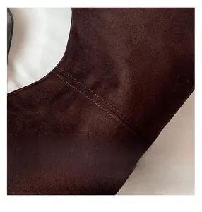 Detailopname van de dubbele stiksels en donkerbruine suède textuur van de schoudertas