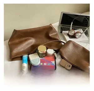 Brown leather tote bag showing spacious interior with tablet and cosmetics inside