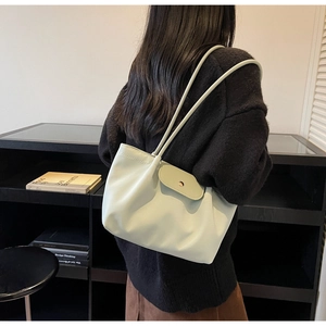 Close-up detail of light mint green tote bag featuring a flap closure and slim shoulder straps