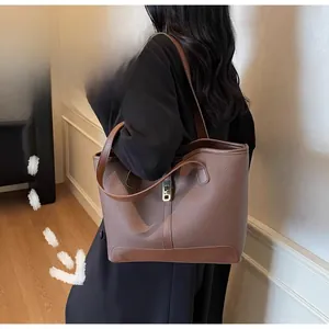 Gros plan du sac cabas en cuir marron grainé avec boucle métallique décorative