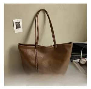 Brown vintage faux leather tote bag showing smooth texture and large capacity