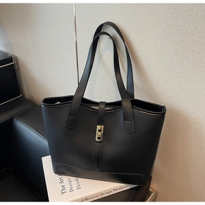 Détail du cabas en cuir noir avec boucle de fermeture rotative en métal doré