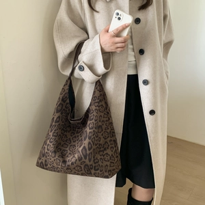 Close-up of leopard print tote bag styled with a beige coat for a trendy autumn look