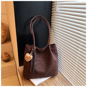 Detail view of large dark brown suede tote bag with cute bear charm and woven rope décor