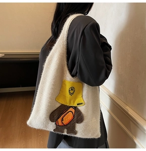 Detail of white fluffy knit tote bag featuring a cute cartoon bear embroidery patch