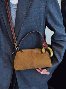 Brown suede pillow bag with golden hardware and adjustable leather shoulder strap