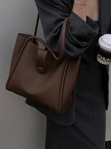 Fashionable dark brown pebble leather tote bag for women in an urban professional setting