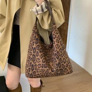 Detail of a large leopard print tote bag with brown leather straps for autumn fashion