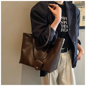 Detailed close-up of dark brown retro oil wax leather tote bag worn by model
