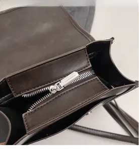 Close-up of smooth silver zipper and interior compartment on vintage brown bag