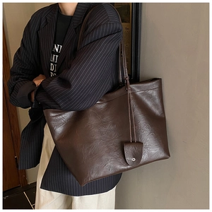 Detail of vintage dark brown faux leather tote bag with small matching accessory pouch