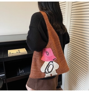 Detailed view of brown knitted tote bag featuring a cute cartoon character embroidery