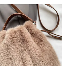 Detail showing soft brown faux fur texture and leather handle of a plush bucket bag