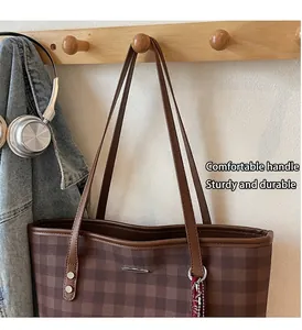 Brown checkered tote bag hanging on wooden hook with casual denim jacket background