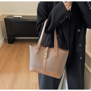 Détail d'un cabas en cuir marron avec un élégant fermoir en métal doré brillant