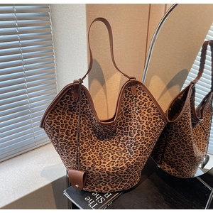 Détail du sac cabas imprimé léopard avec bordure en cuir marron et breloque assortie