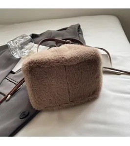 Detail of khaki faux fur bucket bag with leather strap on a stylish suit background