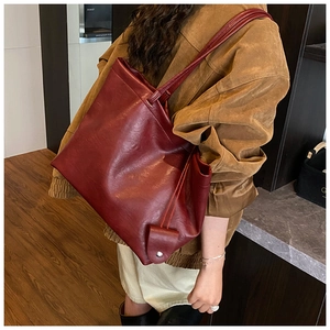 Detail of dark red tote bag in matte PU leather with matching mini coin purse hanging