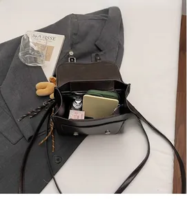 Internal storage detail of the dark brown retro leather shoulder bag with daily items