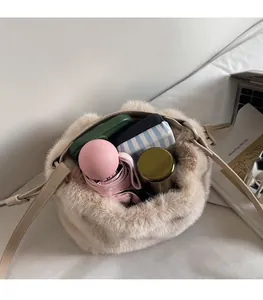 Spacious interior of beige plush bucket bag showing umbrella and cosmetic essentials