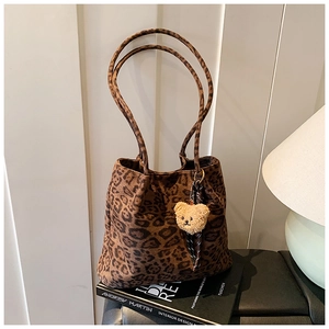 Detail view of brown leopard print tote bag featuring a cute plush bear charm accessory