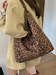 Large leopard print tote bag with brown leather straps shown on a model for daily use