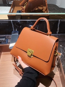 Vintage caramel brown trapezoid leather handbag with gold buckle and adjustable strap