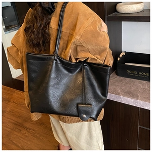 Detail of black PU leather tote bag showing vintage pleated texture and long shoulder straps