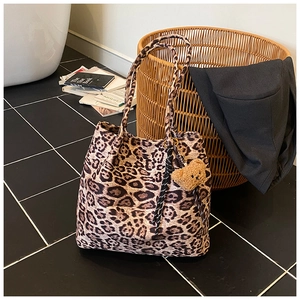 Detail view of leopard print tote bag with bear charm and retro stylish props