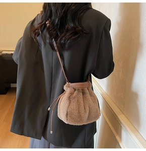 Detail of soft brown faux fur bucket bag with leather drawstring and shoulder strap