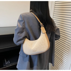 Model view of cream and beige crescent hobo bag featuring leopard print and sleek strap