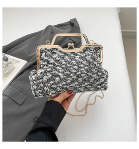Détail de pochette en tweed rétro avec poignée métallique et bandoulière chaîne