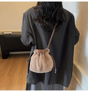 Detail of soft brown faux fur bucket bag with leather drawstring and metal tips