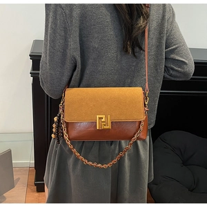 Detail of vintage crossbody bag showing dual-tone leather and geometric gold metal buckle