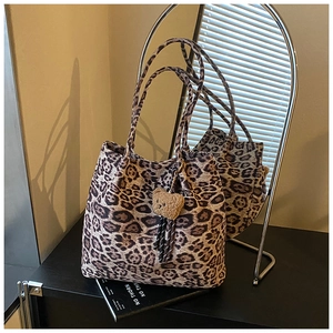 Detail of leopard print tote bag with brown plush bear charm for daily commute