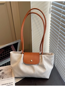 Minimalist white and brown tote bag with gold buckle on a desk with a laptop