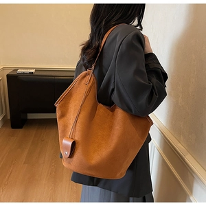 Détail du sac cabas en daim caramel avec bandoulière fine et texture souple