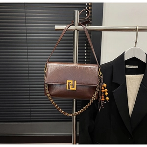 Macro shot of vintage dark brown faux leather bag featuring golden geometric metal buckle
