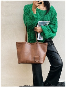 Brown leather tote bag featuring a practical side pocket and long shoulder straps