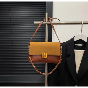 Detail of caramel patchwork shoulder bag featuring suede flap and gold geometric lock