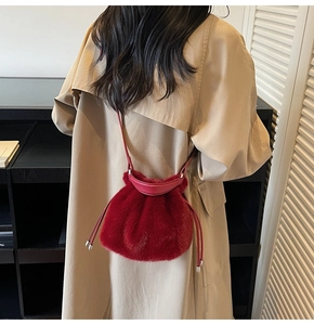 Detail of red faux fur bucket bag with leather drawstring and silver metal hardware