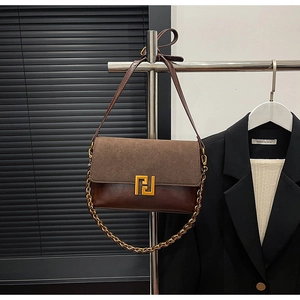 Detailed close-up of dark brown vintage flap bag featuring suede and leather patchwork