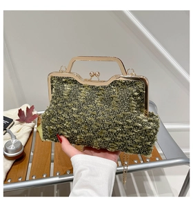 Détail de la texture en tweed vert et du fermoir doré en métal du sac à main vintage