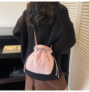Close-up of pink faux fur bucket bag with drawstring closure and leather shoulder strap