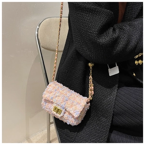 Pink and purple tweed crossbody bag with gold chain strap shown on model's shoulder