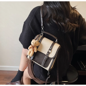 Detail of retro dual-tone beige and brown crossbody bag with cute plush bear charm