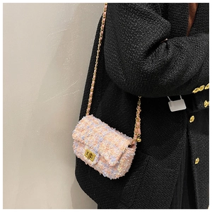Detail of pink tweed crossbody bag with gold chain strap and metal turn-lock closure