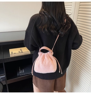 Detail of pink plush bucket bag with drawstring closure and soft faux fur texture