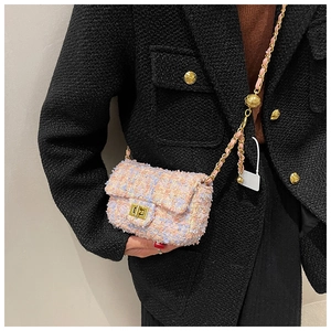 Close-up of multicolor tweed texture and gold twist lock on a stylish crossbody bag